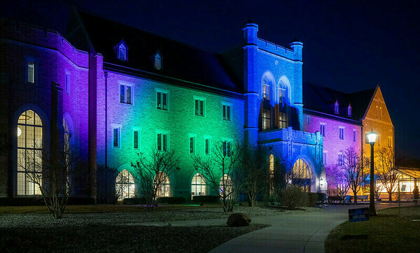 The Jordan Hall of Science is lit in purple, lime green, blue, and pink for Rare Disease Day 2024.